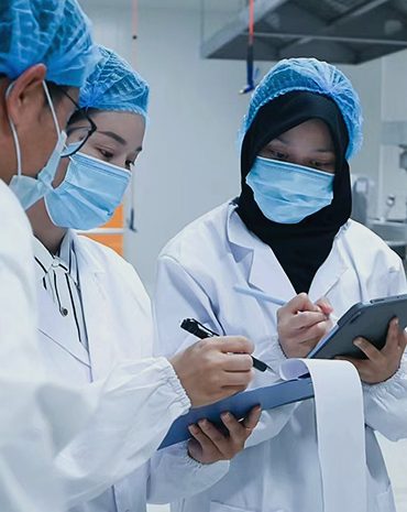 Quality control technicians recording batch data in a supplement cleanroom